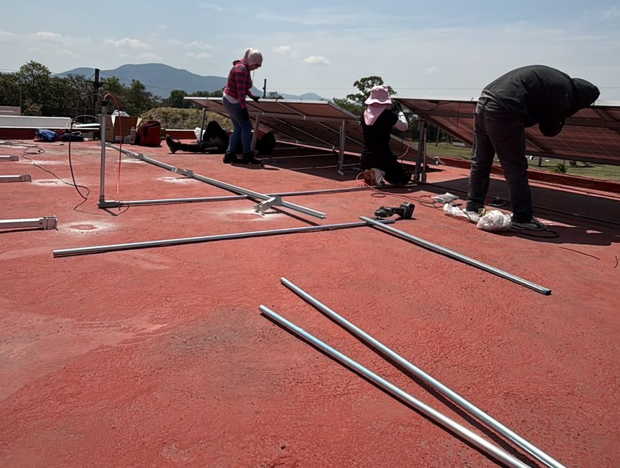 Instaladores armando la estructura de montaje sobre una azotea